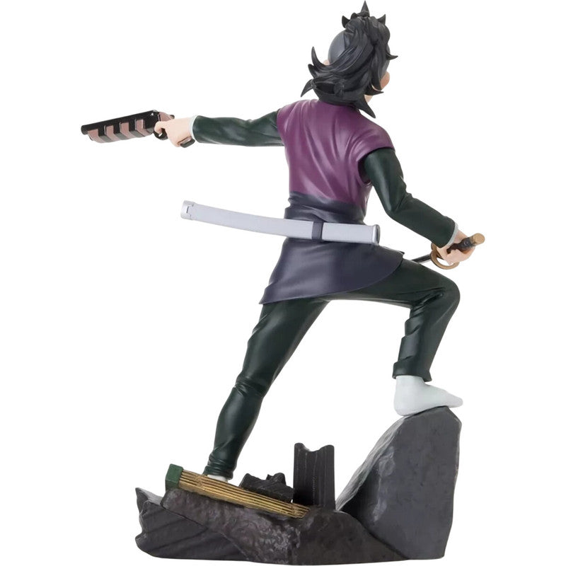 Back view of anime figure of a male character with a sword and pistol wearing a green and purple outfit standing on a rocky terrain base