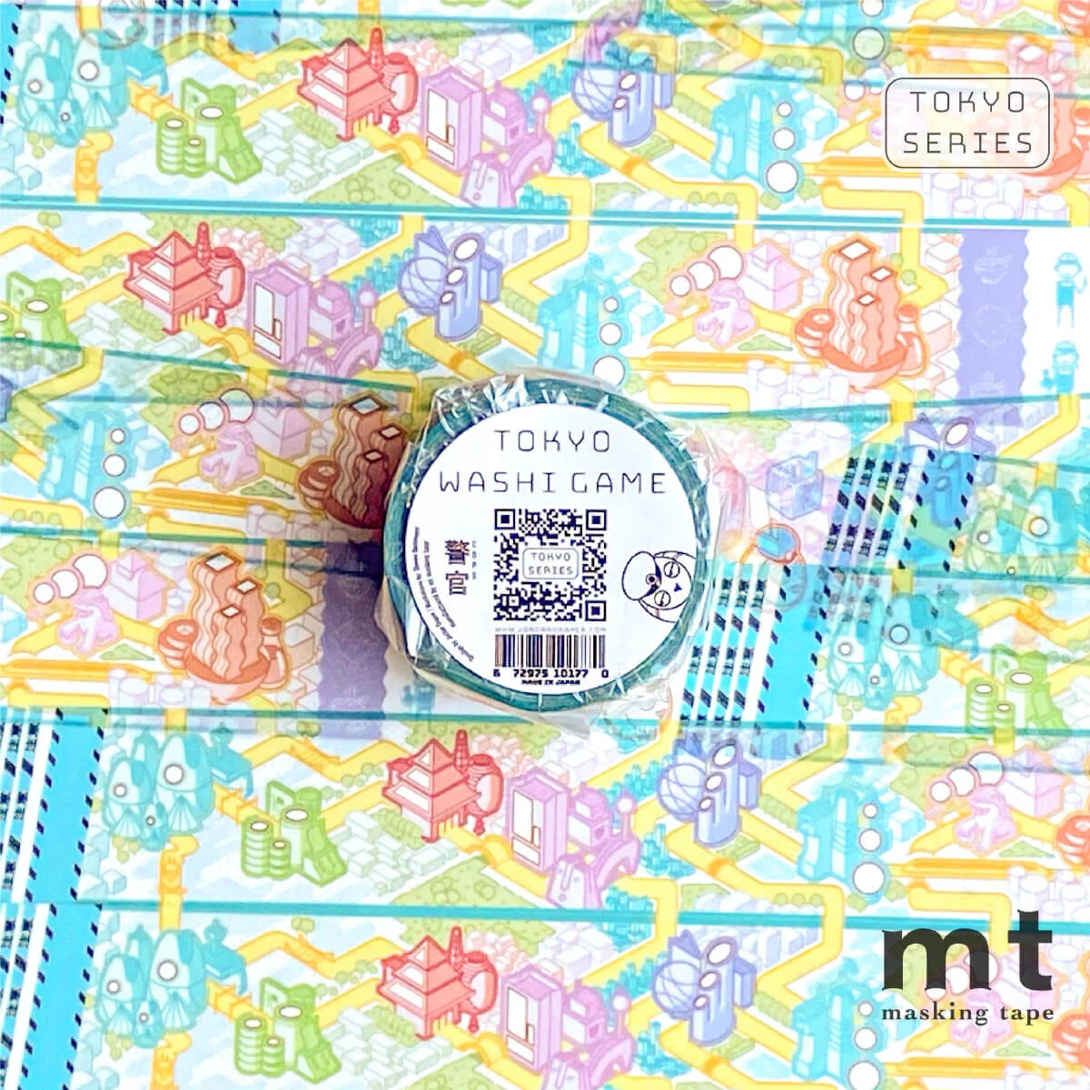 A Tokyo Washi Game roll featuring a police character on its label rests on the same tape's unfolded pattern of a colourful isometric city game board
