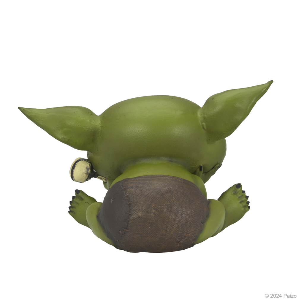 Back view of a sitting green baby goblin figure wearing a patched brown diaper and a bone charm on its ear