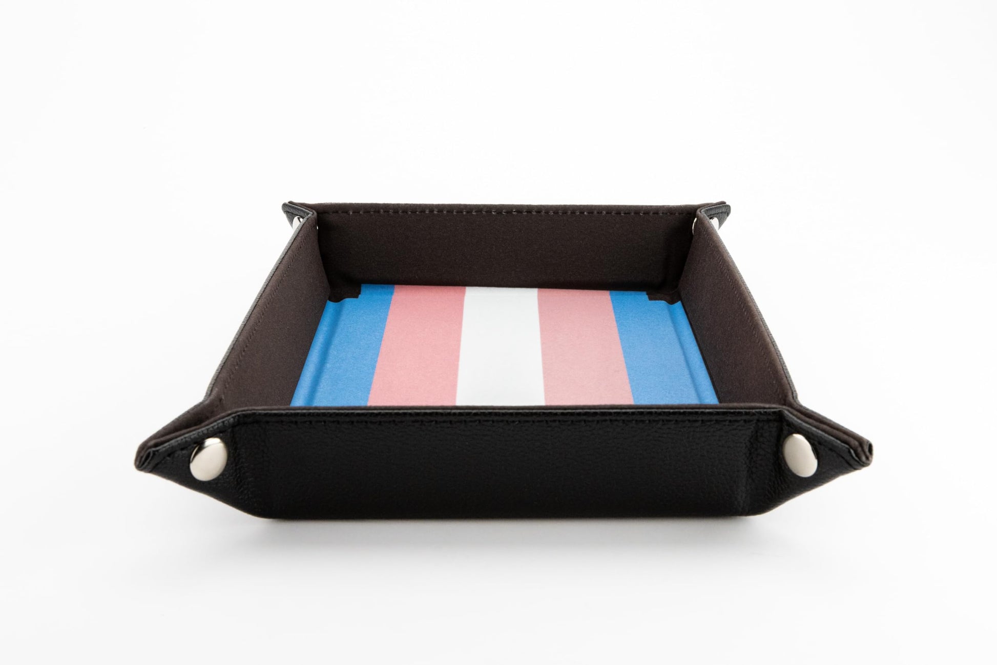 Foldable black dice tray with silver corner snaps and an interior surface printed with the distinctive blue pink and white Transgender Pride flag