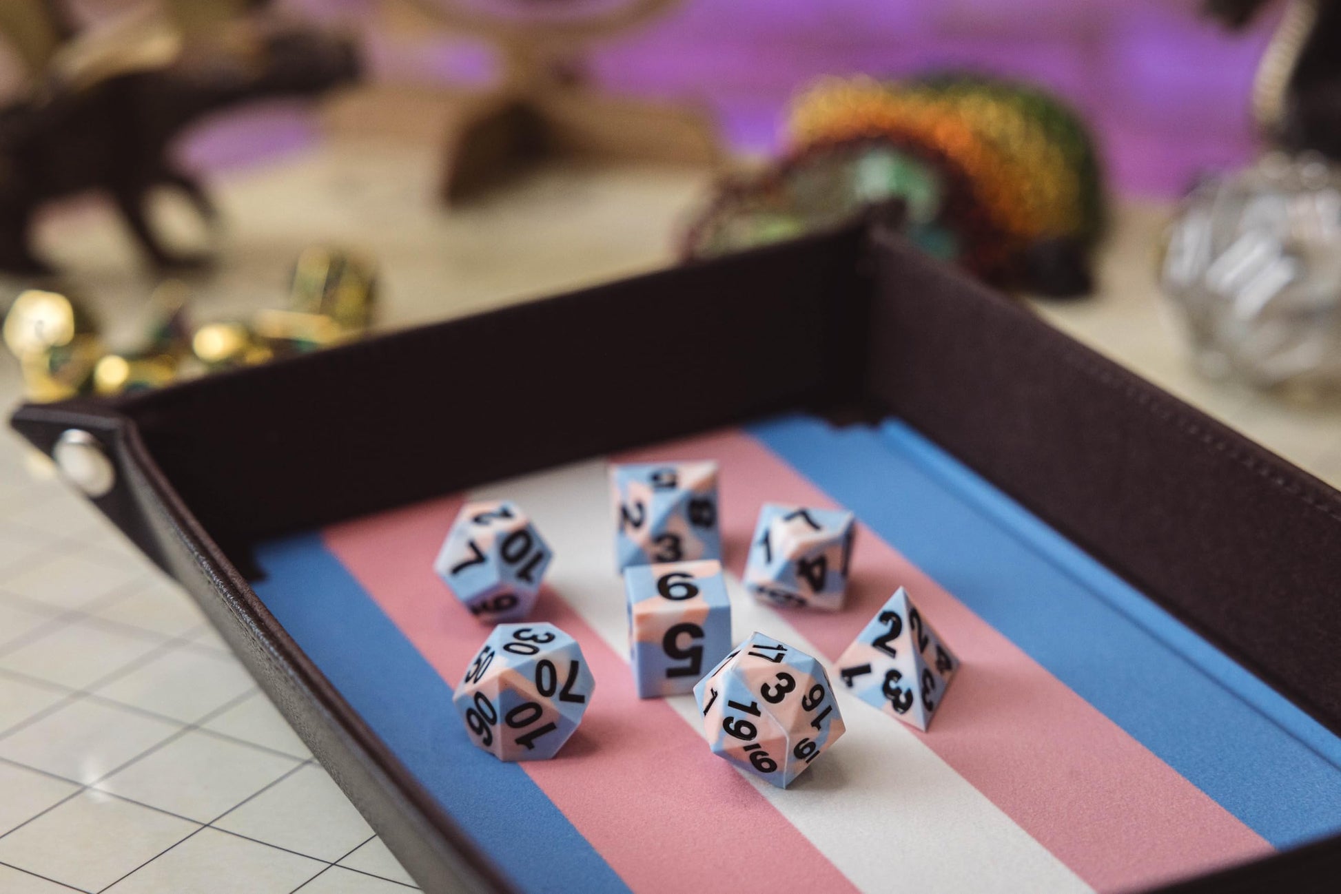 This foldable Fanroll velvet dice tray with Transgender flag stripes holds a complete set of matching pink and blue polyhedral gaming dice