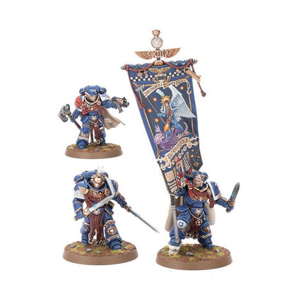 Three Ultramarines Space Marine miniatures, including a standard bearer with a large blue banner