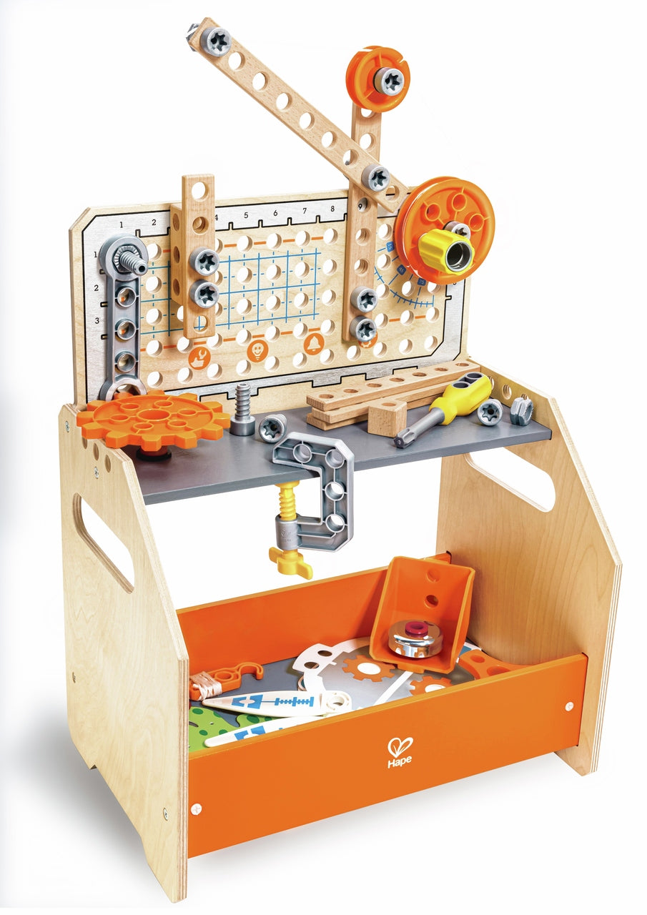 The Hape Discovery Scientific Workbench made of light wood featuring an upright pegboard, orange gears, a mounted c-clamp, and a lower orange storage bin