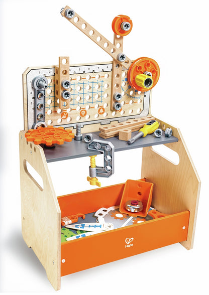The Hape Discovery Scientific Workbench made of light wood featuring an upright pegboard, orange gears, a mounted c-clamp, and a lower orange storage bin