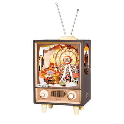 The Rolife Music Box Sunset Carnival is a retro television model featuring rabbit-ear antennae and an illuminated diorama of a Ferris wheel and circus grounds inside the screen