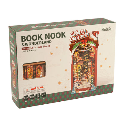 Packaging for the Rolife Book Nook Christmas Street DIY kit showcasing the illuminated 289-piece winter wonderland diorama built into a bookshelf insert