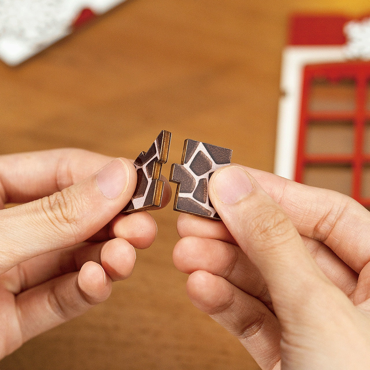 Hands connect two interlocking wooden puzzle pieces with a dark cobblestone pattern, showcasing the assembly of the Christmas DIY Bookends Kit