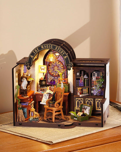 The assembled DIY Mini House kit displays "The Magic Study," a mystical scene complete with an enchanted desk, books of magic botany, a tiny owl, and a lighted arched window