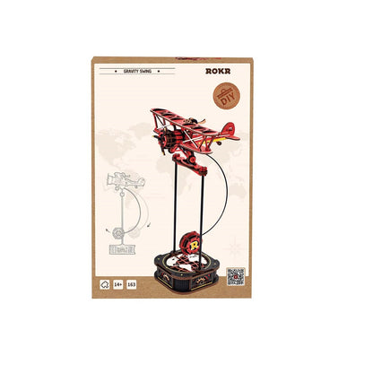 Packaging for the ROKR Gravity Swing Sky Captain DIY kit displays the assembled red biplane model swinging over a decorative wooden base