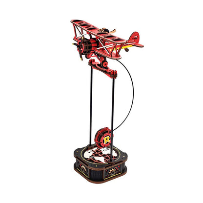 The ROKR Gravity Swing Sky Captain wooden puzzle model showing the red biplane mounted on a tall stand above a globe-themed base