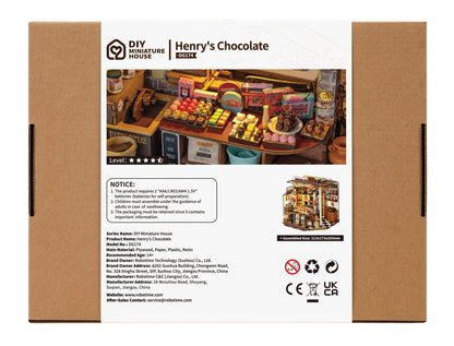 The retail box for the DG174 Henry's Chocolate DIY miniature house kit shows a detailed shop display overflowing with colorful candies and truffles, with an assembled size of 213x173x203mm