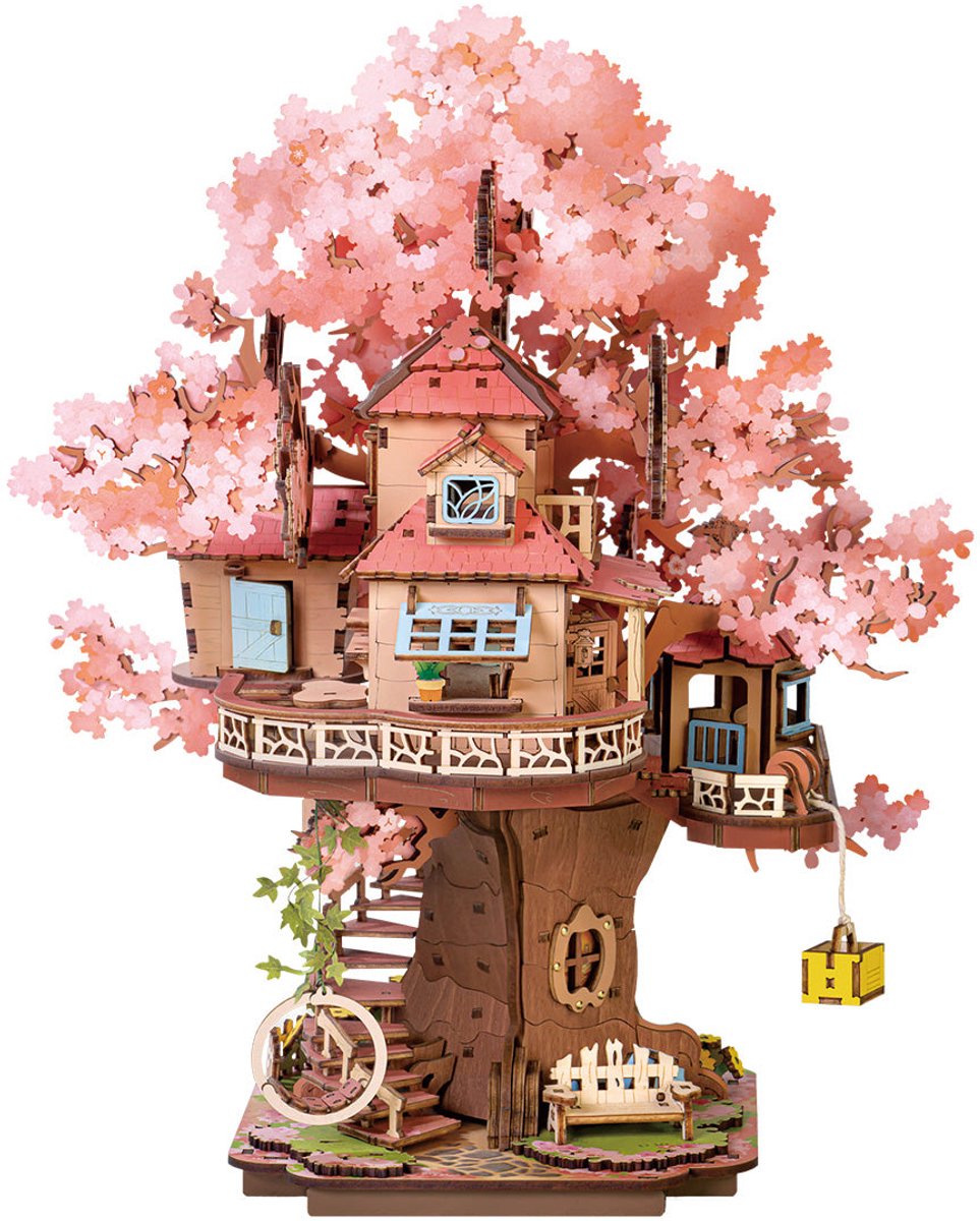 This intricate wooden 3D puzzle shows a cozy multi-level treehouse nestled among pink cherry blossoms with miniature furniture and winding exterior stairs