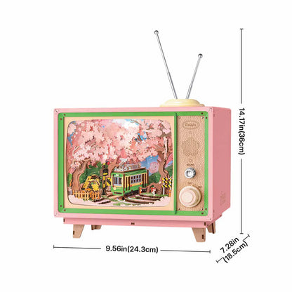 This pink retro TV-style music box featuring a cherry blossom trolley scene is dimensioned as 956in wide 1417in high and 728in deep