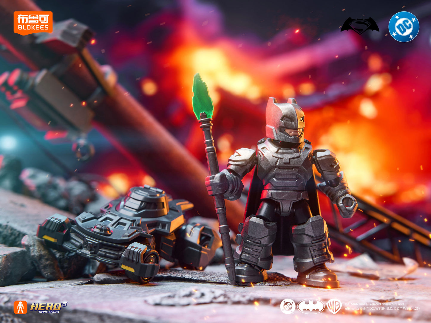Armored Batman block figure holding a Kryptonite spear, standing over a wrecked Batmobile amid explosions