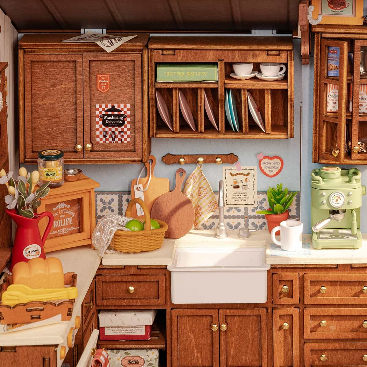 Detailed miniature wooden kitchen scene featuring cabinets, sink, and a mint green espresso maker