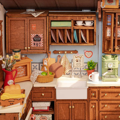 Detailed miniature wooden kitchen scene featuring cabinets, sink, and a mint green espresso maker