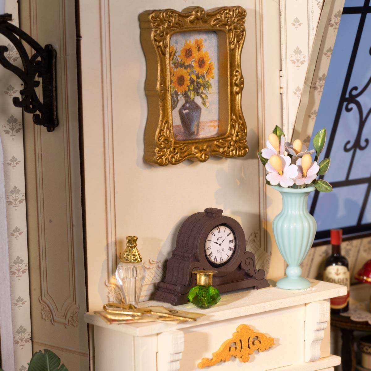 Miniature interior featuring a clock, vase of flowers, and a framed sunflower painting on a dresser