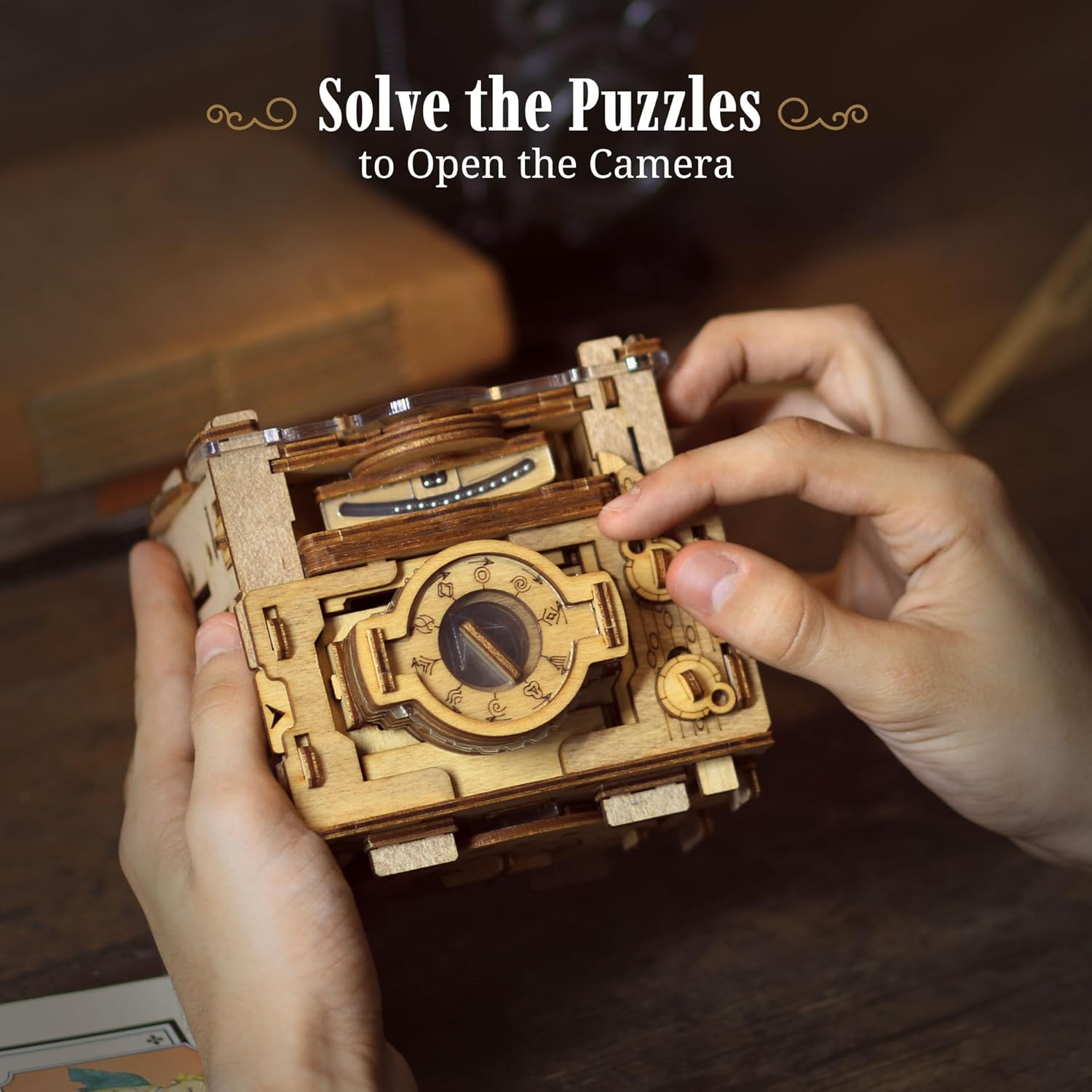 Hands manipulating the dials on an intricate wooden mechanical puzzle box shaped like a camera