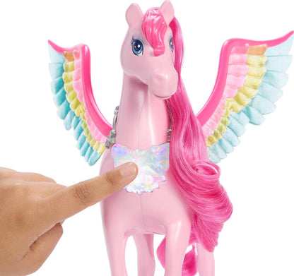 A finger presses the iridescent chest piece of a pink Pegasus toy with pink mane and rainbow wings