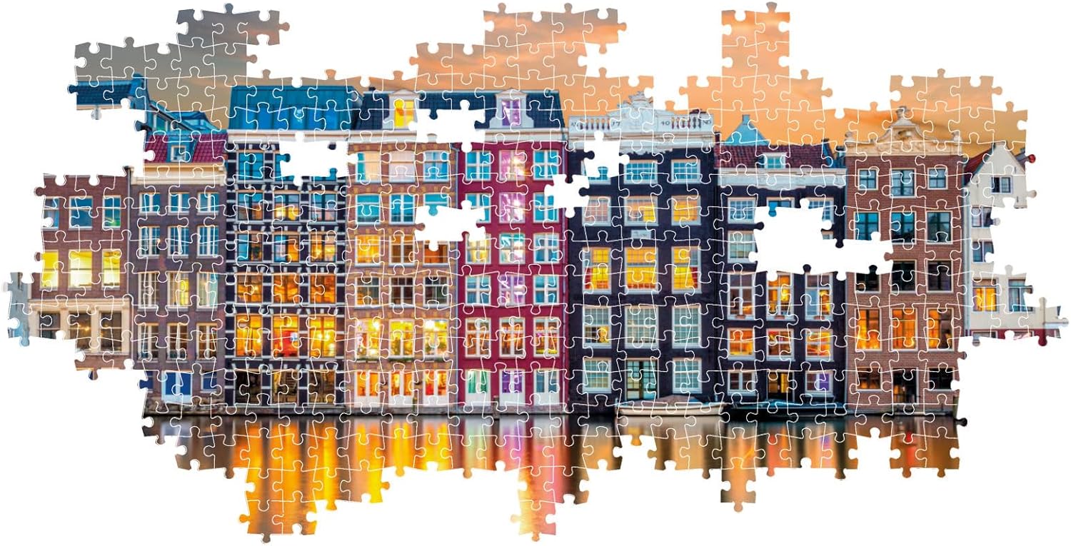 Partially completed jigsaw puzzle featuring colorful canal houses illuminated at night reflecting on the water
