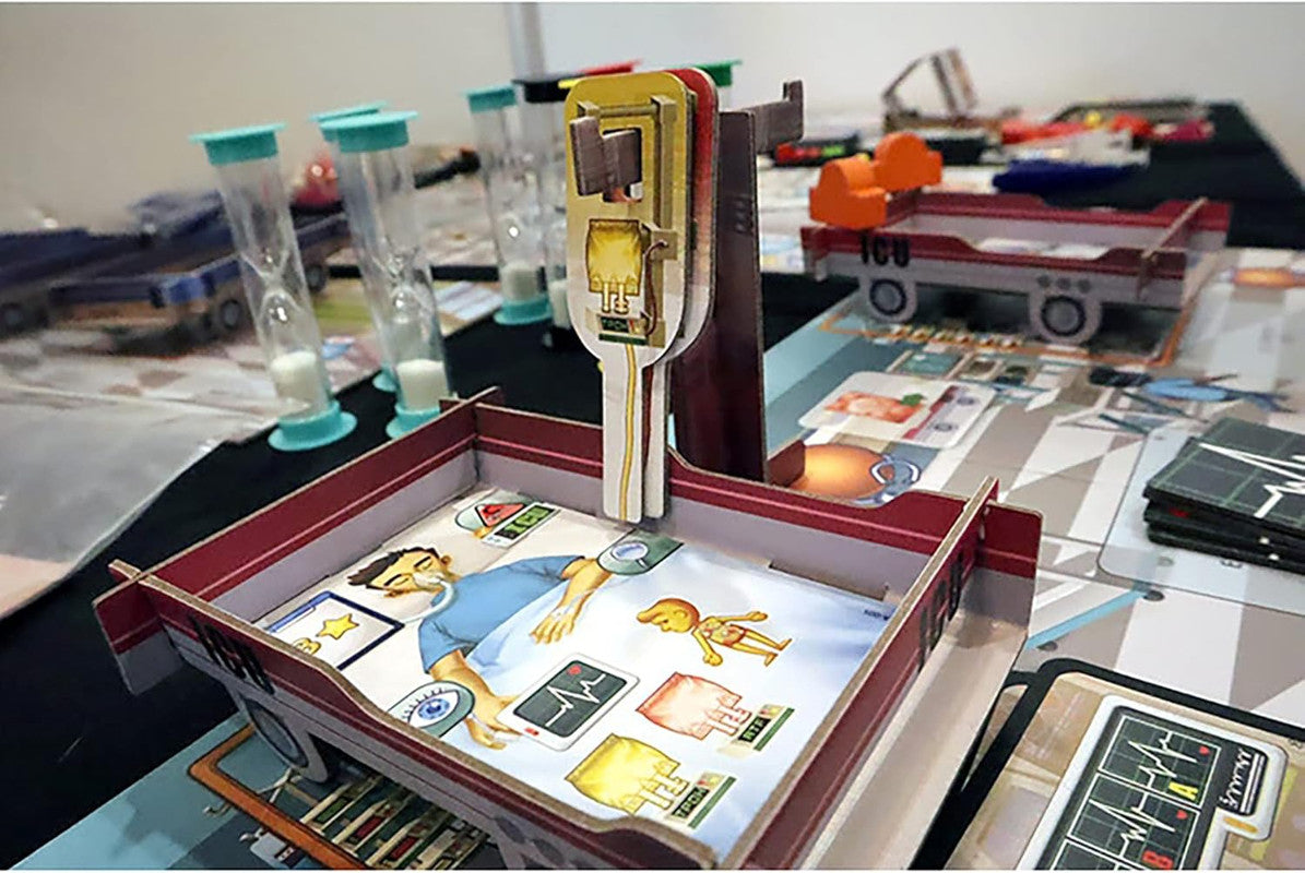 Rush M.D.: ICU Expansion board game with a cardboard patient in a bed, an ICU cart, hourglass timers, and medical cards