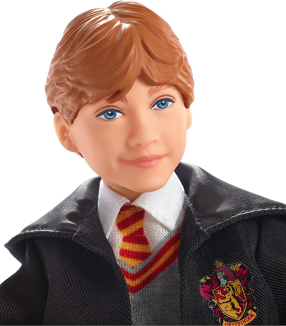 Close-up of a Ron Weasley doll with brown hair and blue eyes, wearing a Gryffindor Hogwarts uniform
