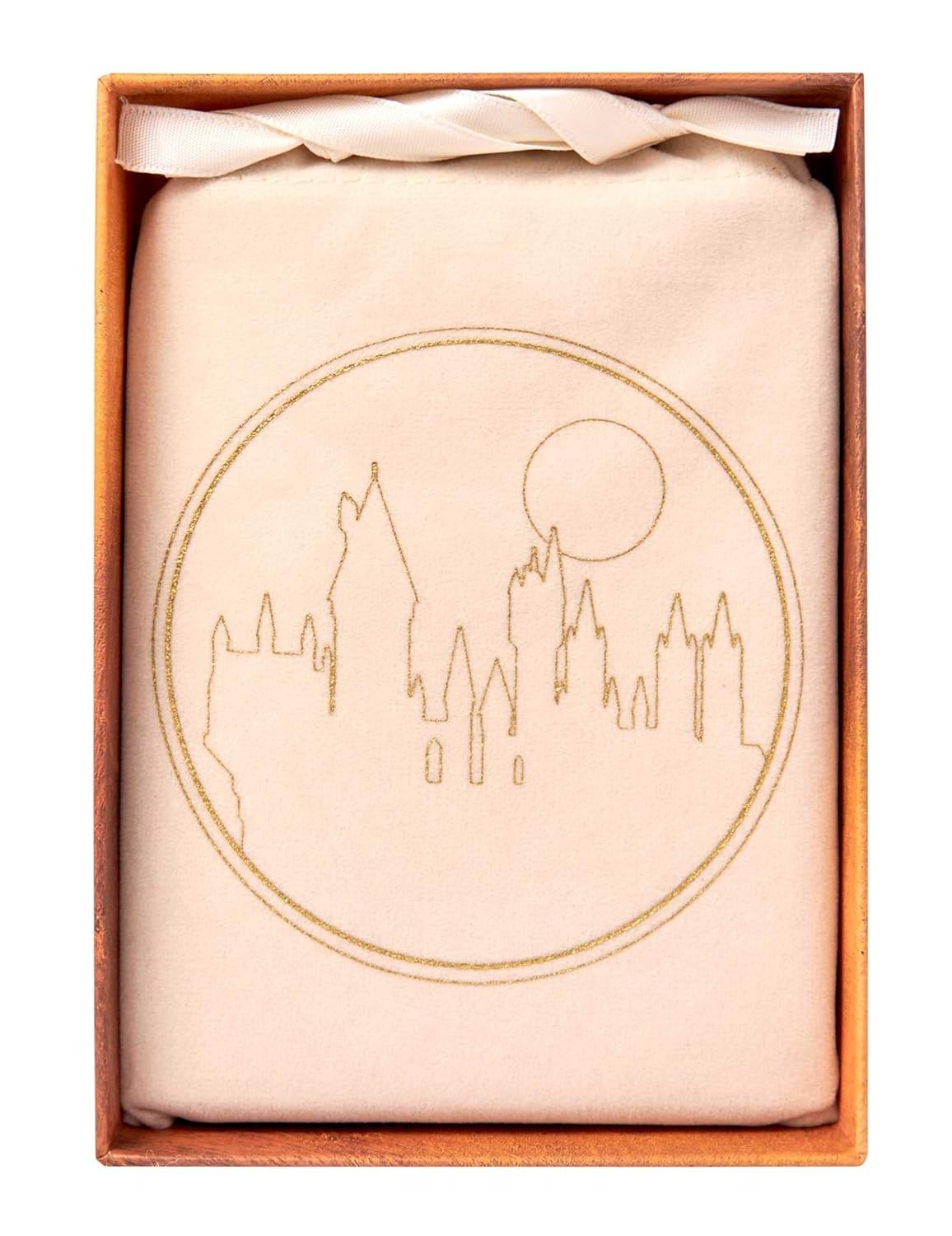 Cream fabric in open box with gold embroidered Hogwarts castle and moon