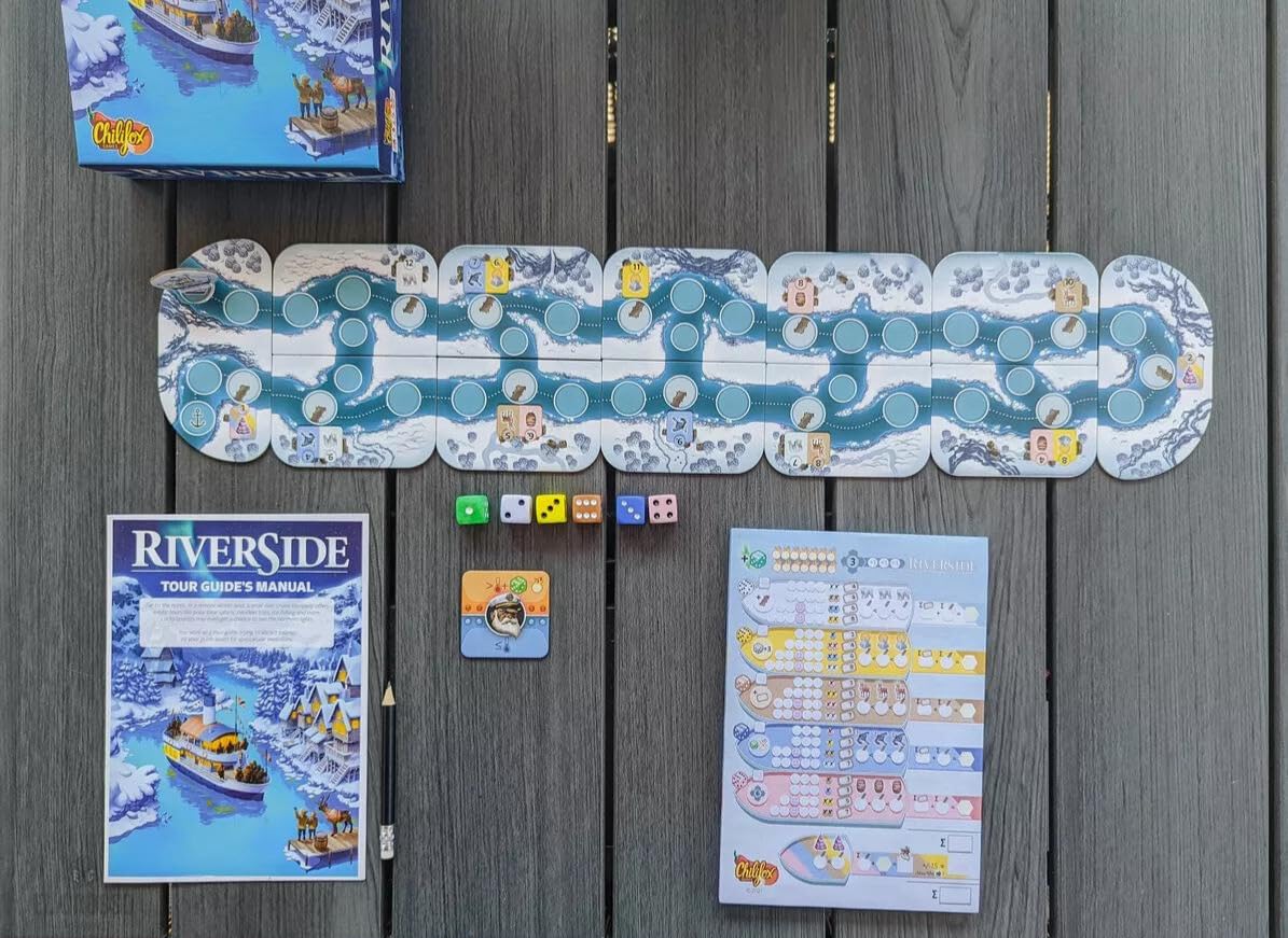 Close-up of Riverside game components with colorful dice and scoring sheets