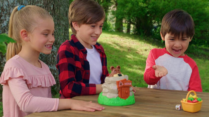 Three happy children play an outdoor Beware of The Bear board game with a pop-up bear toy on a wooden table
