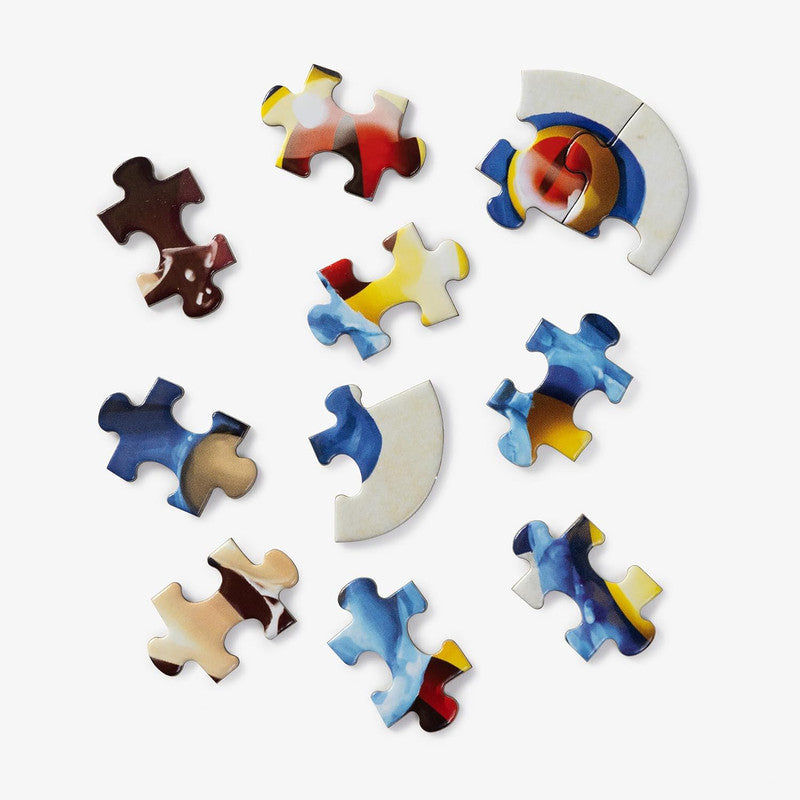 Scattered colorful, abstract jigsaw puzzle pieces on a white background, with two pieces connected to form a quarter circle