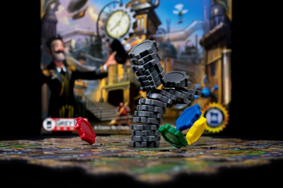 Steampunk board game with a precarious stack of grey gear tokens and scattered coloured pieces on a puzzle board base