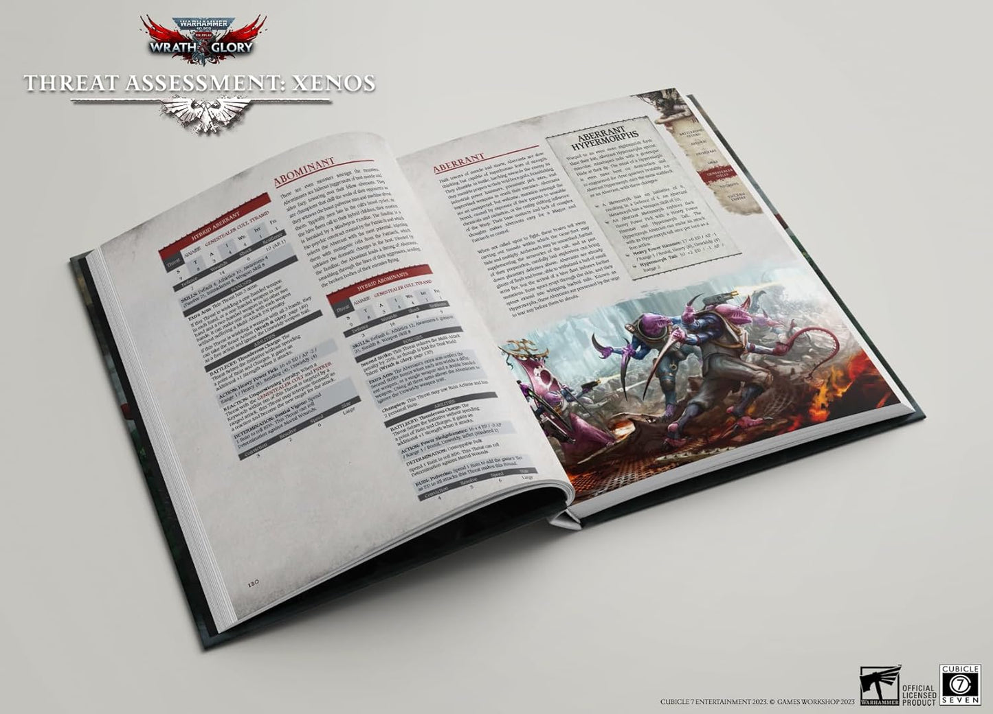 An open Warhammer 40K rulebook displays a page with an illustration of three purple, dynamic alien Xenos in a combat scene