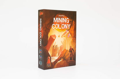 Board game box for "Mining Colony" featuring a miner in a futuristic cave surrounded by glowing crystals