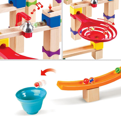 Marbles moving through wooden and colorful plastic components of a modular marble run, featuring a bell and spinner
