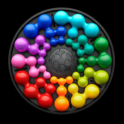 IQ Deluxe Circle, glossy molecular puzzle pieces arranged in a rainbow wheel on a black tray