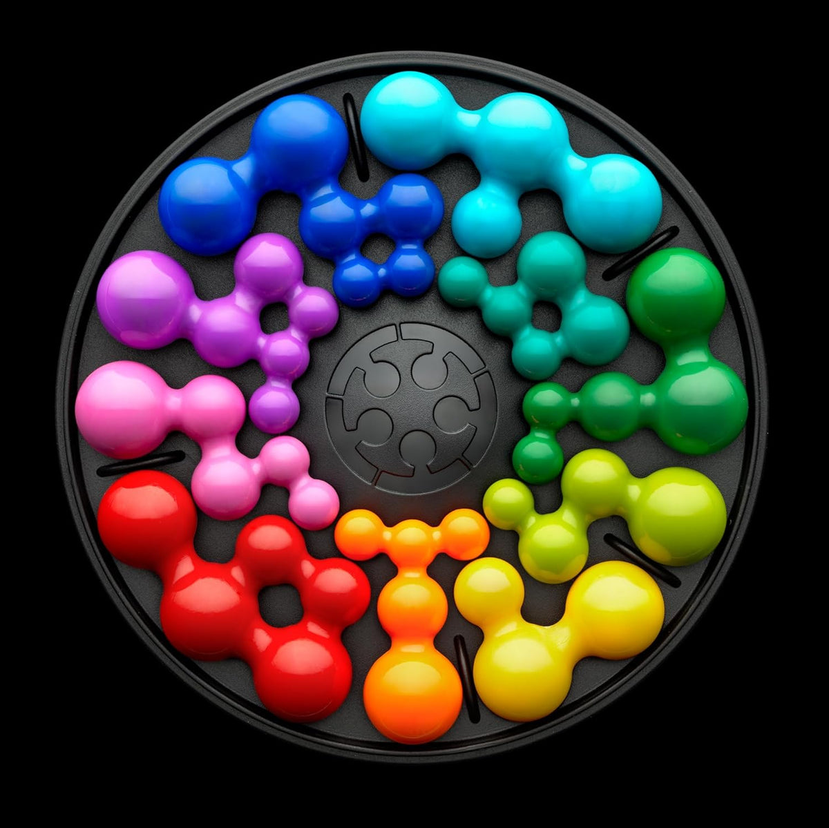 IQ Deluxe Circle, glossy molecular puzzle pieces arranged in a rainbow wheel on a black tray