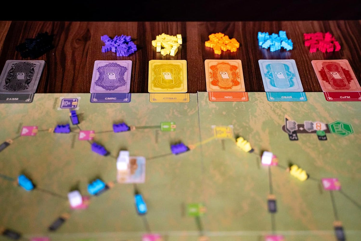 Board game setup: Piles of multi-colored pieces, matching cards with toilet paper icons, and a map board with various tokens