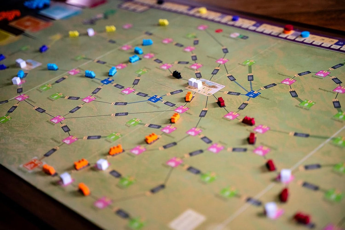 A board game featuring colorful train pieces on a green map with interconnected cities