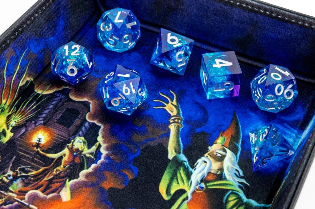 Translucent blue polyhedral dice set on a dark, fantasy-themed dice tray with a wizard illustration