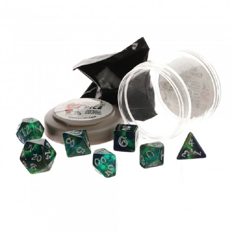 Seven green and purple nebula-patterned polyhedral dice with silver numbers are displayed with their clear container and round box
