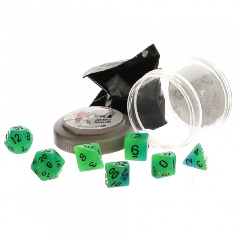 Seven glowing green and blue polyhedral Dungeon Dice are shown scattered beside their clear plastic container, which has a grey lid labeled ReaperMini