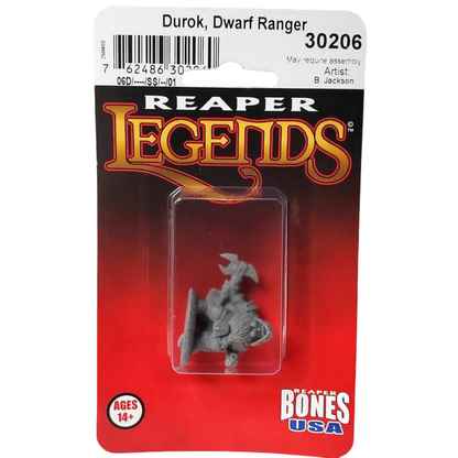 A gray unpainted Reaper Legends Durok Dwarf Ranger miniature, holding an axe and shield, sealed in a red blister pack displaying 'Reaper Bones USA' and 'Ages 14+'