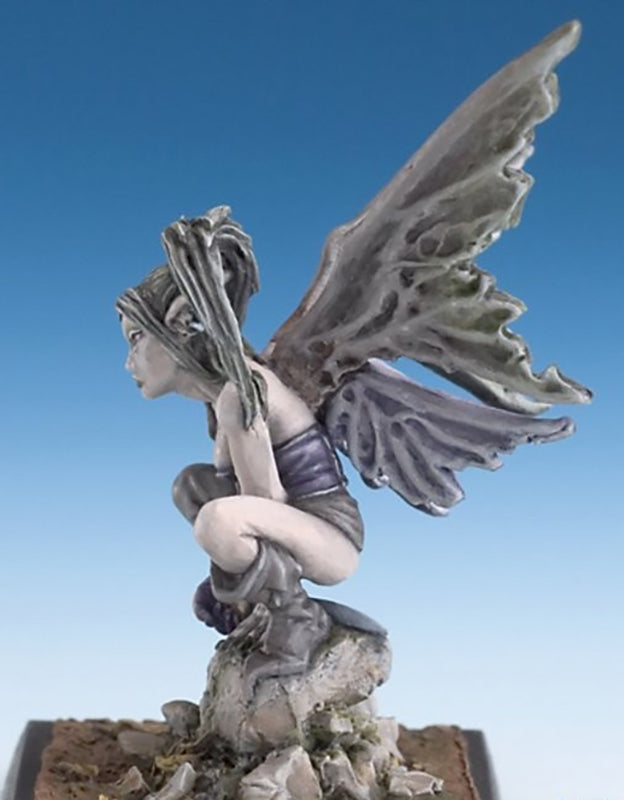 Miniature dark fairy figure perched on rocks; pale skin, crouching pose, large grey-purple ragged wings, blue background