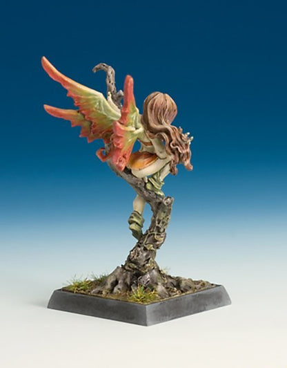 Fantasy miniature of a fairy with autumn-colored wings perched on a gnarled tree stump base