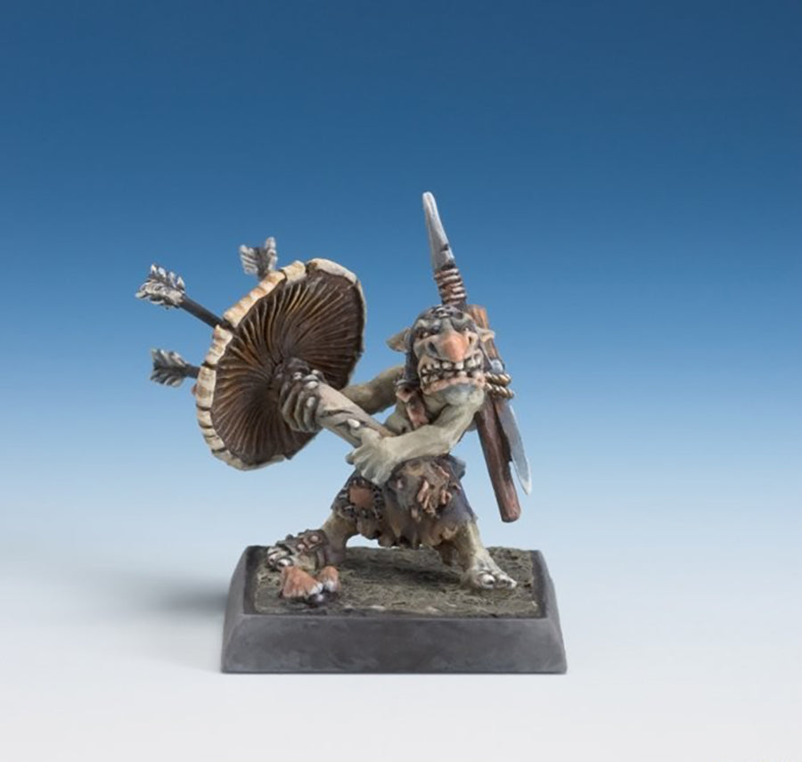 Painted fantasy miniature of a snarling goblin defending with a spear and a large mushroom shield stuck with three arrows