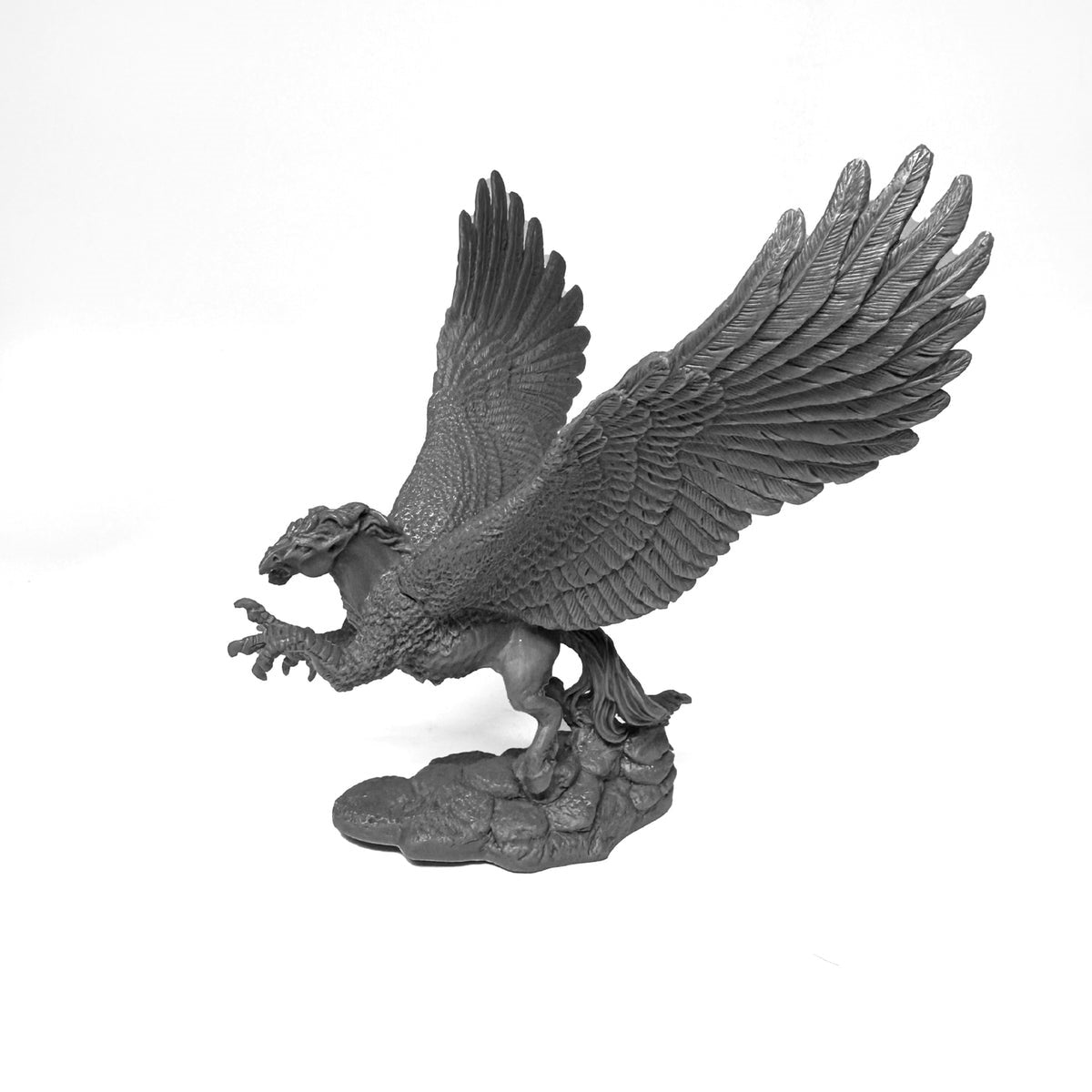 A gray Reaper Bones Black Hippogriff miniature with its large wings outstretched, standing on a textured rock base