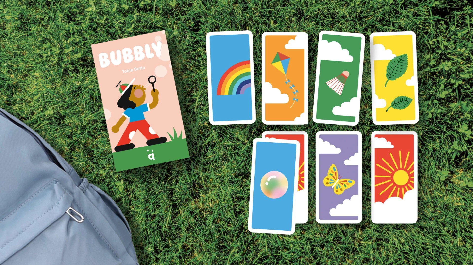 Bubbly card game box and cards setup on a grass layout