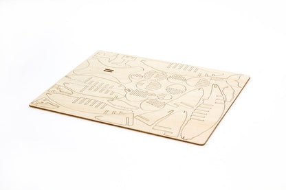 Light brown wood sheet with laser-cut pieces for a 3D humpback whale model kit