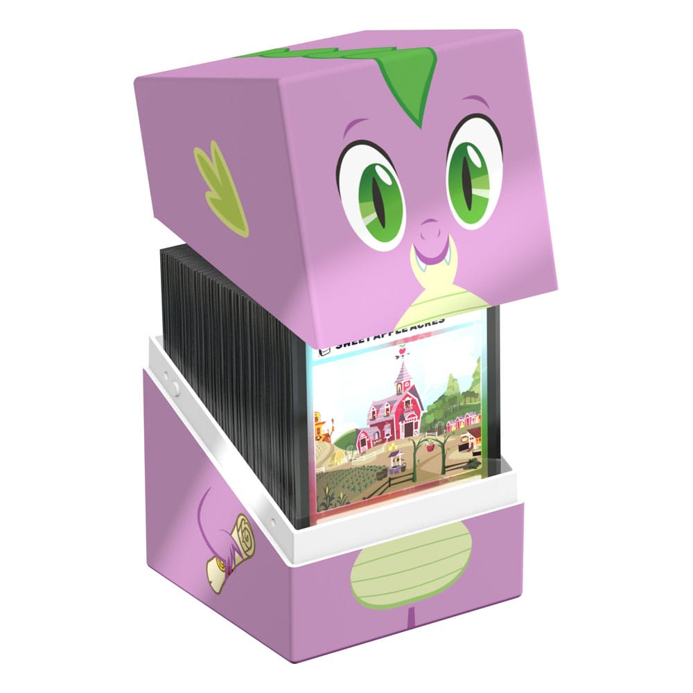 A purple and green Ultimate Guard Squaroes deck box shaped like Spike from My Little Pony is open, displaying a stack of cards with a farm scene