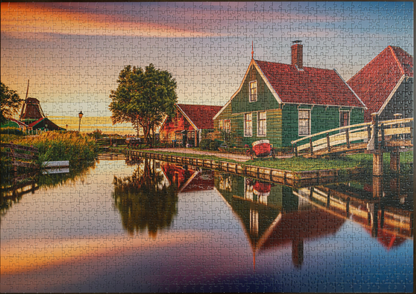 A completed Clementoni Zaanse Schans 1500 Piece Puzzle showing a scenic Dutch village with canals, houses, a bridge, and a windmill at sunset